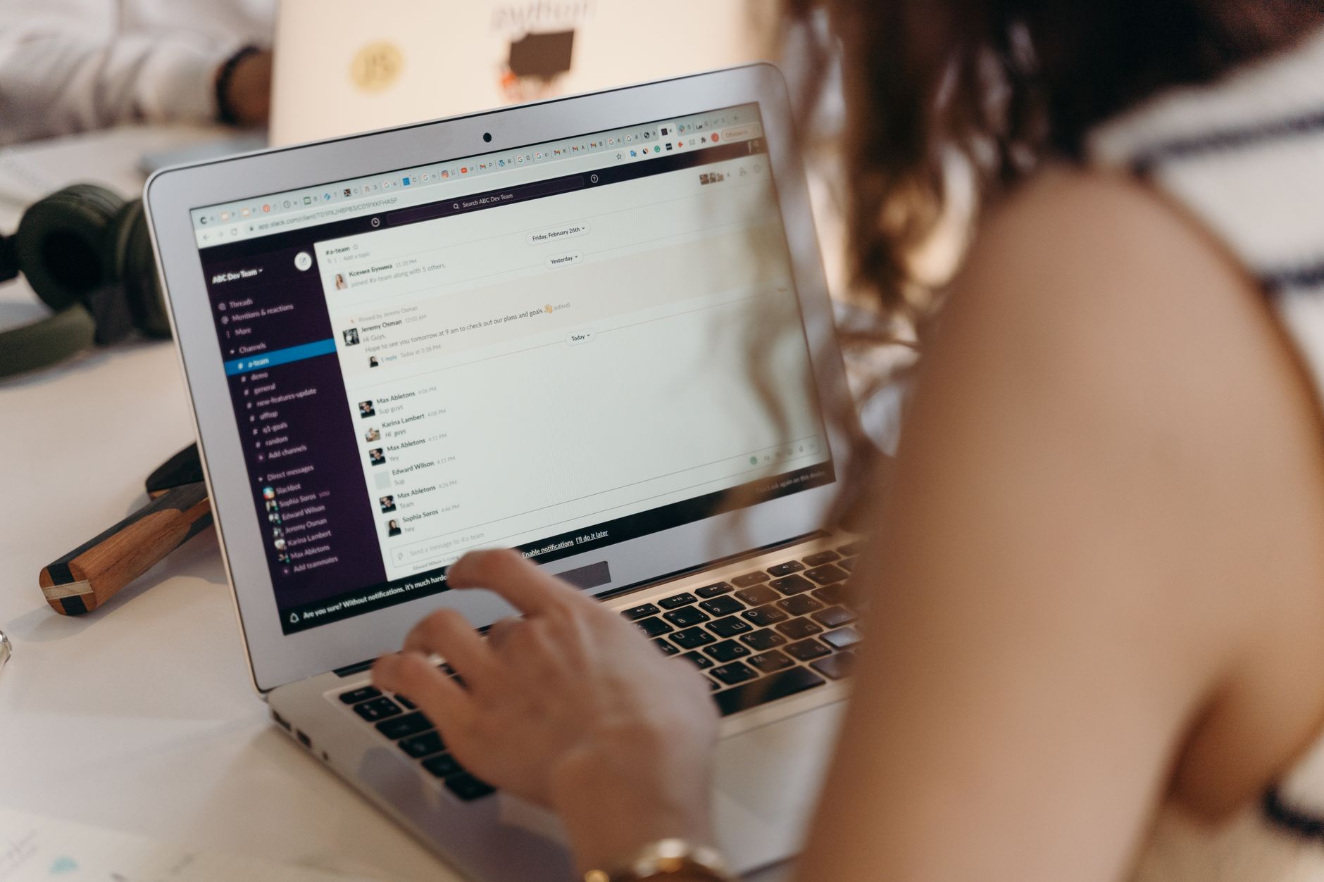 A person working at a desk managing email newsletters on a laptop