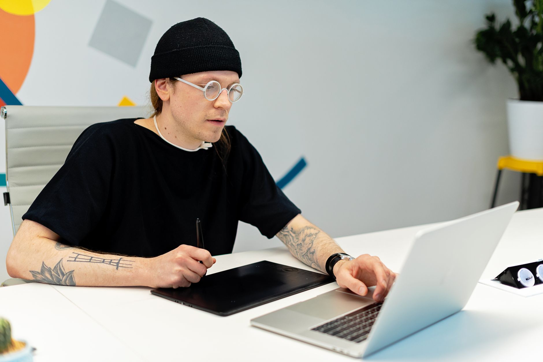 A designer working on social media content using a laptop at a clean desk workspace