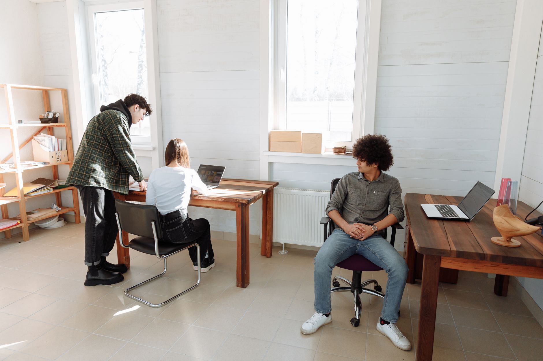 A small marketing team reviewing digital creative assets on a monitor in an office setting